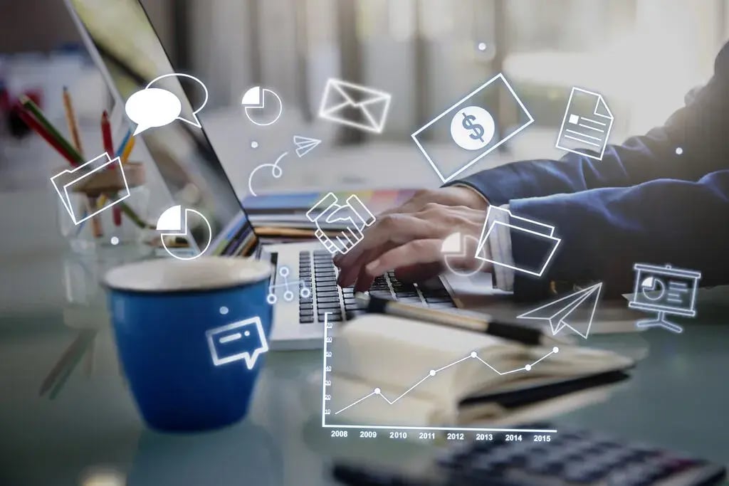 Profissional digitando no notebook com ilustrações digitais sobrepostas representando canais de mídia, gráficos, dados de comunicação e relatórios.