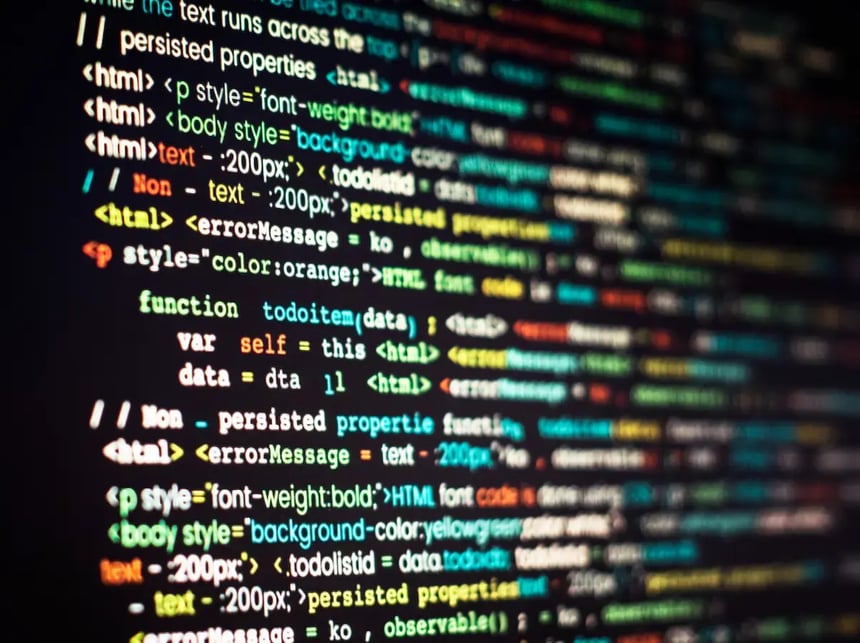 Tela de computador exibindo linhas de código HTML coloridas, representando o uso de meta tags como Title Tag e Tag Canonical em páginas da web