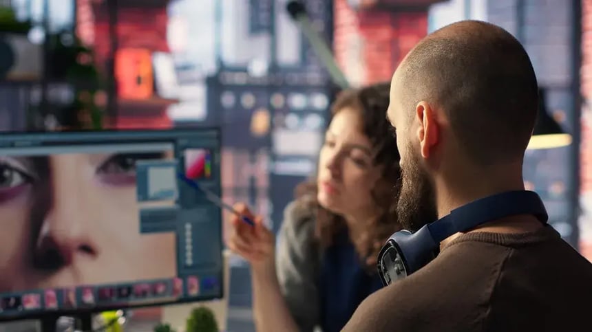 Designers editando anúncio e vídeo publicitário em monitor para campanha de TV 3.0 no Brasil.